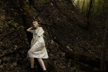 Portrait of a beautiful mysterious woman with blond hair in the forest. like a fairytale. Warm tone	
