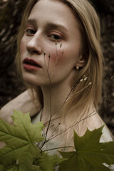 Portrait of a beautiful mysterious woman with blond hair in the forest. like a fairytale. Warm tone	
