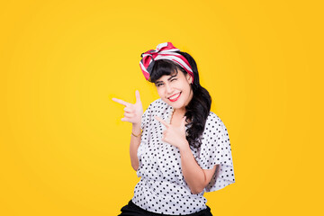 Wow, Closeup red head young woman pretty amazed pinup girl in button shirt excited surprised shocked looking up to side retro vintage 50s hairstyle on yellow wall. Cute face expression