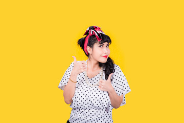 Wow, Closeup red head young woman pretty amazed pinup girl in button shirt excited surprised shocked looking up to side retro vintage 50s hairstyle on yellow wall. Cute face expression