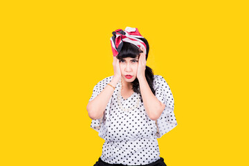 Wow, Closeup red head young woman pretty amazed pinup girl in button shirt excited surprised shocked looking up to side retro vintage 50s hairstyle on yellow wall. Cute face expression