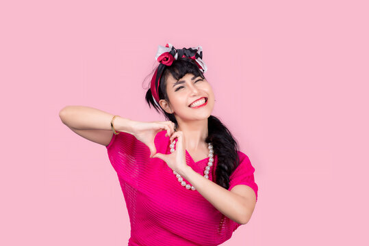 Attractive energetic Asian woman happy isolated on pink studio background.Retro vintage 50's style Emotion face expressi