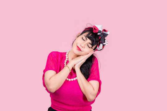 Attractive energetic Asian woman happy isolated on pink studio background.Retro vintage 50's style Emotion face expressi