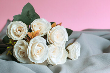 Beautiful roses on grey cloth with pink background