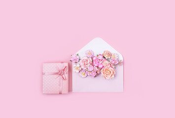 paper envelope with flowers and gift box on pink background. Mother's day, 8 march, birthday, Valentine's day, 14 february romantic gift concept. flat lay