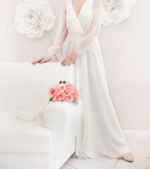 wedding photo with a white dress and a bouquet of pink roses on a light background