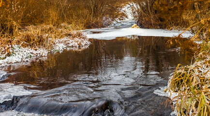 Fast river with ice in late autumn
