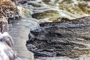 Fast river with ice and snow in late autumn