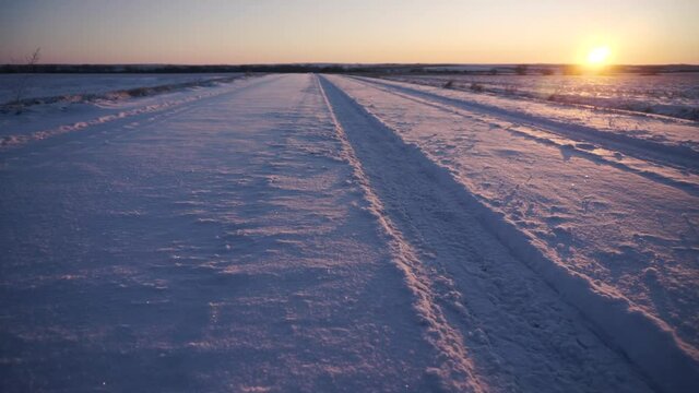 Tire Tracks on Snowy Road During Sunset