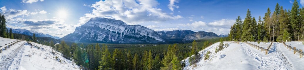 Obraz premium Banff National Park beautiful mountain landscape. Panorama view Mount Rundle valley forest and Bow River in snowy autumn sunny day. Hoodoos Viewpoint, Canadian Rockies.
