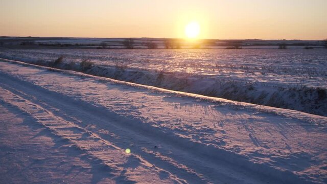 Dolly Shot of Snowy Road at Sunset 