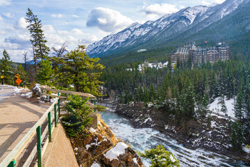Fairmont Banff Springs and Bow River Falls in snowy autumn sunny day. View from Surprise Corner Viewpoint. Banff National Park, Canadian Rockies.