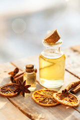 Concept of natural essential oils: orange, cinnamon sticks, anise. Home spa treatment. Aromatherapy, holiday spirit. Winter home fragrances blend. Bright light, close up, macro. Copy space for text