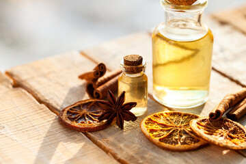 Concept of natural essential oils: orange, cinnamon sticks, anise. Home spa treatment. Aromatherapy, holiday spirit. Winter home fragrances blend. Bright light, close up, macro. Copy space for text