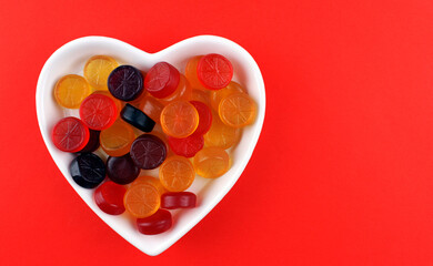 Multicolored gummy candies in a white heart-shaped plate