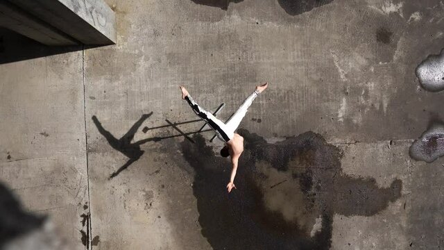 Circus artist turning around and keeps balance on one hand, view from the top. Concept of motion, movement and control