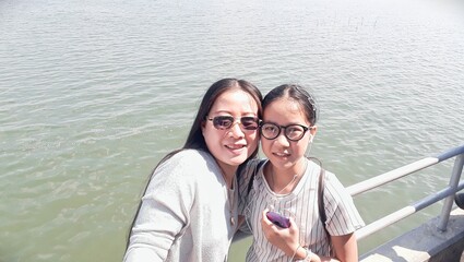 Woman and girl traveling beside the sea of holiday weekend in Thailand.