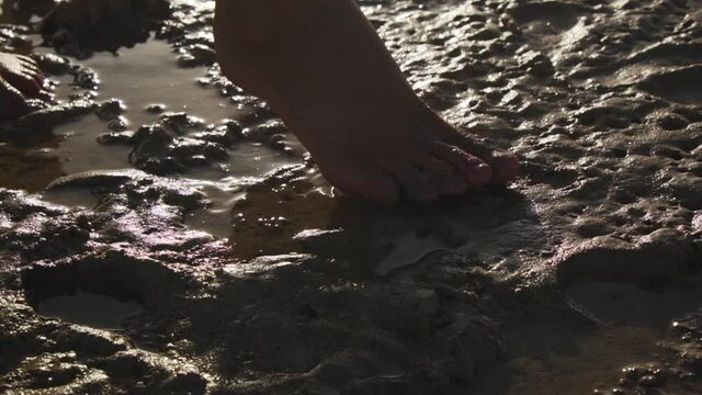 close up of handsome females feet dancing in mud slow motion