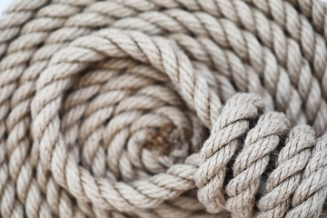 Braided thick rope tied in a skein. Hemp rope for decoration and design. Background from a fishing rope.
