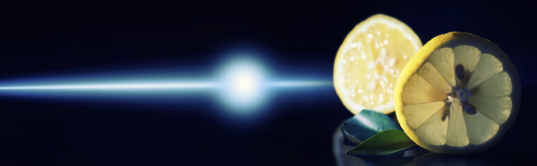Composition with orange and grapefruit slices on a black background. A slice of orange with back light on a black background with water drops. Juicy orange on a table.