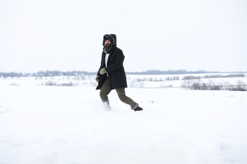Bearded man in the winter woods. Attractive happy young man with beard walk in the park.