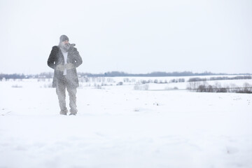 Bearded man in the winter woods. Attractive happy young man with beard walk in the park.