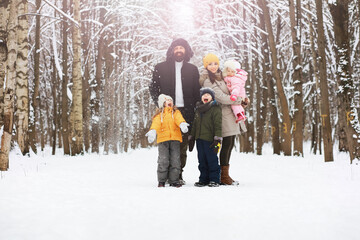 Happy family playing and laughing in winter outdoors in the snow. City park winter day.