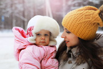 Obraz premium Happy family playing and laughing in winter outdoors in the snow. City park winter day.