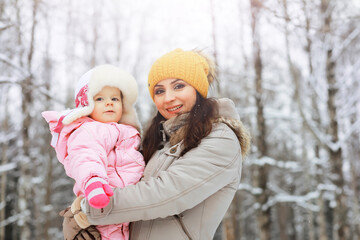 Fototapeta premium Happy family playing and laughing in winter outdoors in the snow. City park winter day.
