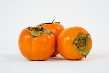 Persimmon on a white background. Fruit kinglet on white background. Organic goldcrest in wooden box. Organic, health fruit. Copy space. Food market.