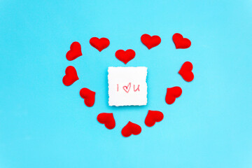 a note on which is written a declaration of love in lipstick, lies on a blue background, surrounded...