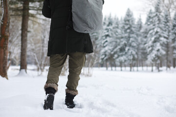 Outdoor portrait of handsome man in coat and scurf. Bearded man in the winter woods.