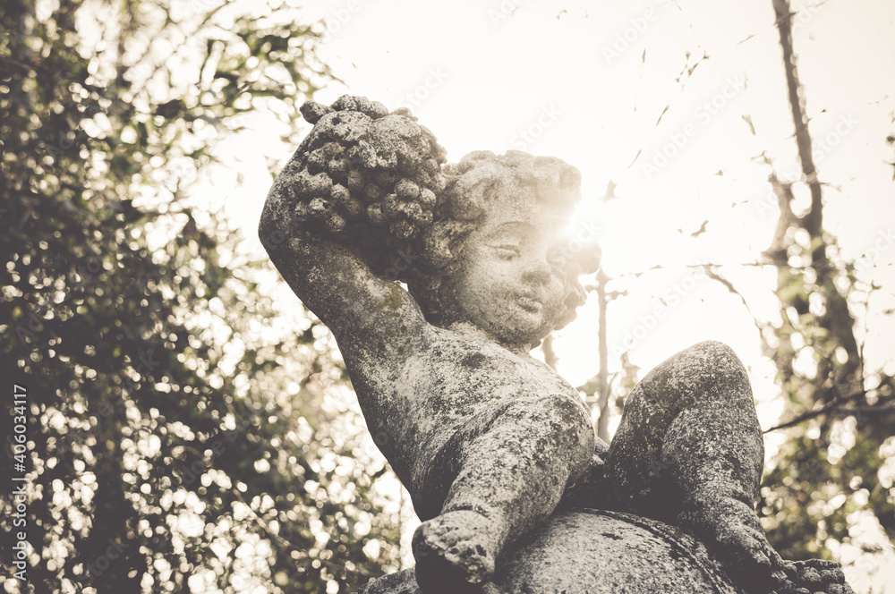 Sticker Low angle shot of a young angel statue face under sunlight