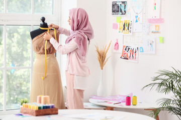 Female Muslim fashion designer working in studio