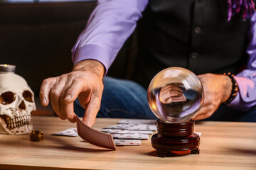 Male fortune teller with cards reading future at table, closeup