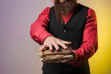 Male fortune teller with spell book on color background