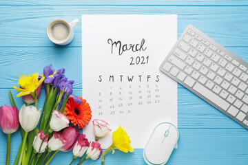 Calendar, computer keyboard, coffee and flowers on color wooden background