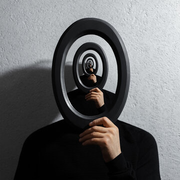 Enigmatic surrealistic optical illusion, young man holding round frame on textured grey background.