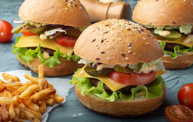Three burgers with French fries. Burgers with beef patty.