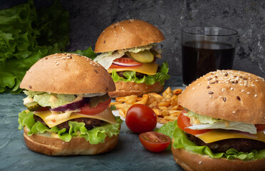 Three burgers with French fries. Burgers with beef patty.