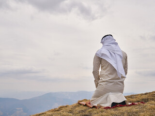 A muslim person pray in the mountains