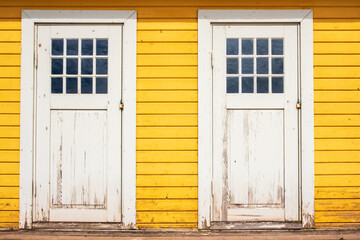 White wooden doors on yellow beach huts