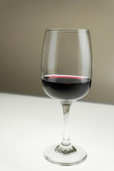 Glass of red wine on a blurred background. Vertical photo