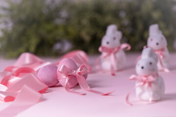 Pink painted egg with a ribbon surrounded with decorations