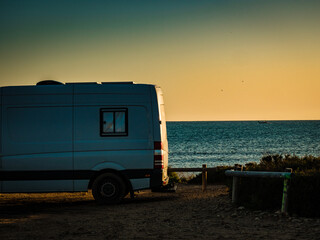 Camper rv on sea at sunrise