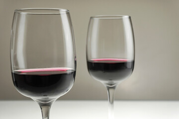 Two glasses of red wine on a blurred homogeneous background. Horizontal photo