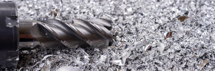 Panoramic image. Silver end mill cutter with metal shavings. Processing of ferrous metals in a factory © kelifamily