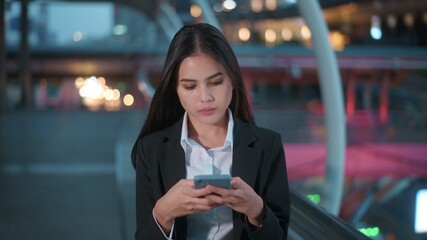 A young business woman wearing black suit is using smart phone , in the city, Business Lifestyle Concept..