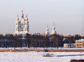 Two river icebreaking tugs are breaking the ice on the Neva, against the backdrop of the Smolny...