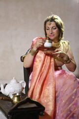 Woman in Indian dress drinking coffee